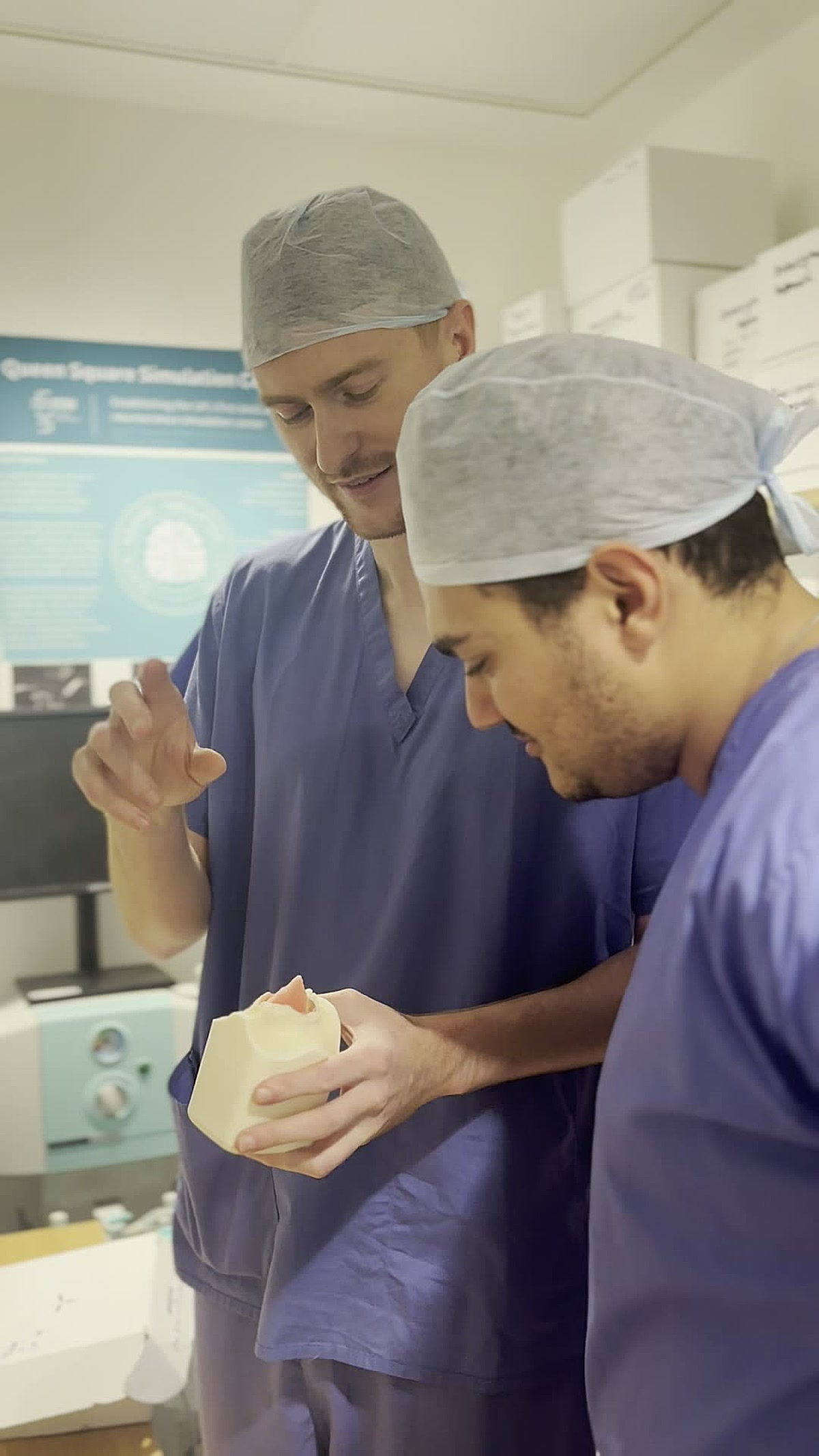 George Hudson discussing a 3D-printed skull base model with a colleague at the Queen Square Simulation Centre